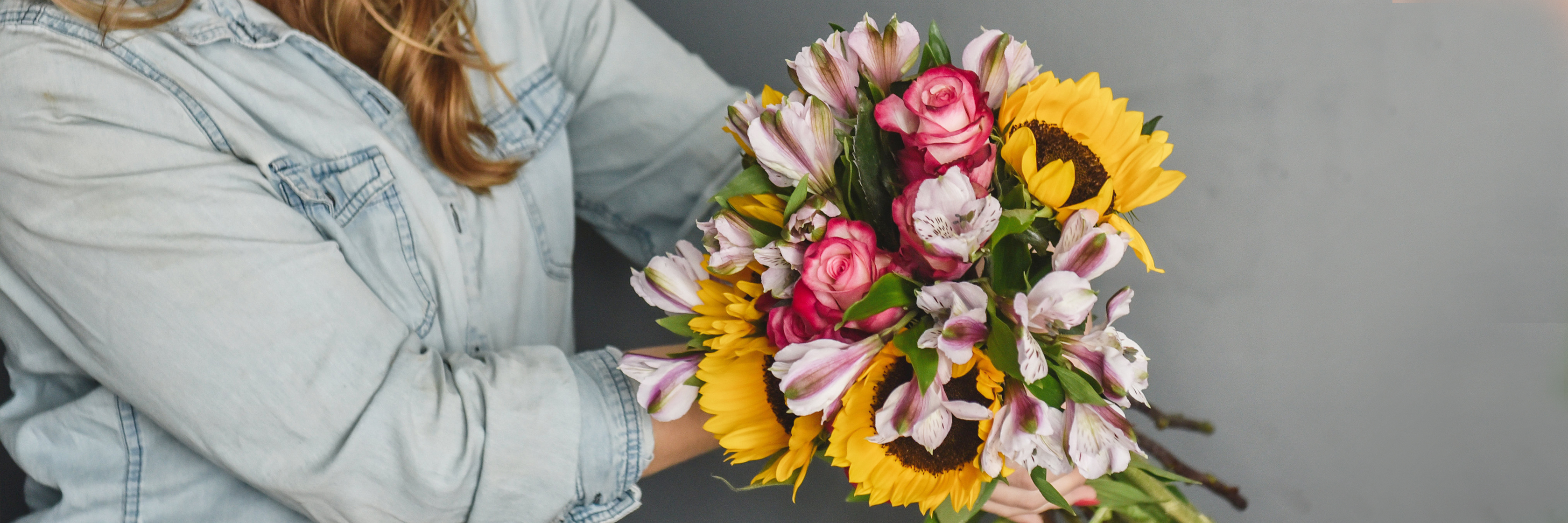 A vibrant bouquet featuring sunflowers, pink roses, and delicate lilies, perfect for celebrations.