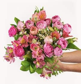 Vibrant bouquet of pink roses and alstroemeria, elegantly held by hands, perfect for celebrations.