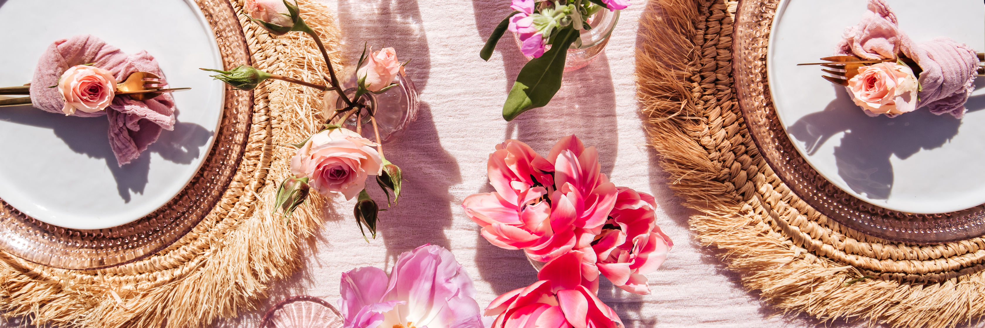 Elegant table setting with pink roses and vibrant tulips, enhancing a festive dining experience.