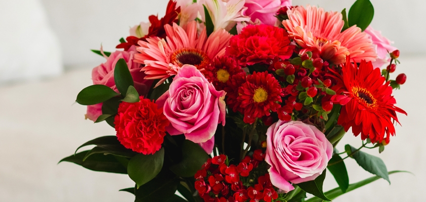 Vibrant bouquet featuring pink roses, gerbera daisies, and red blooms, perfect for celebrations.
