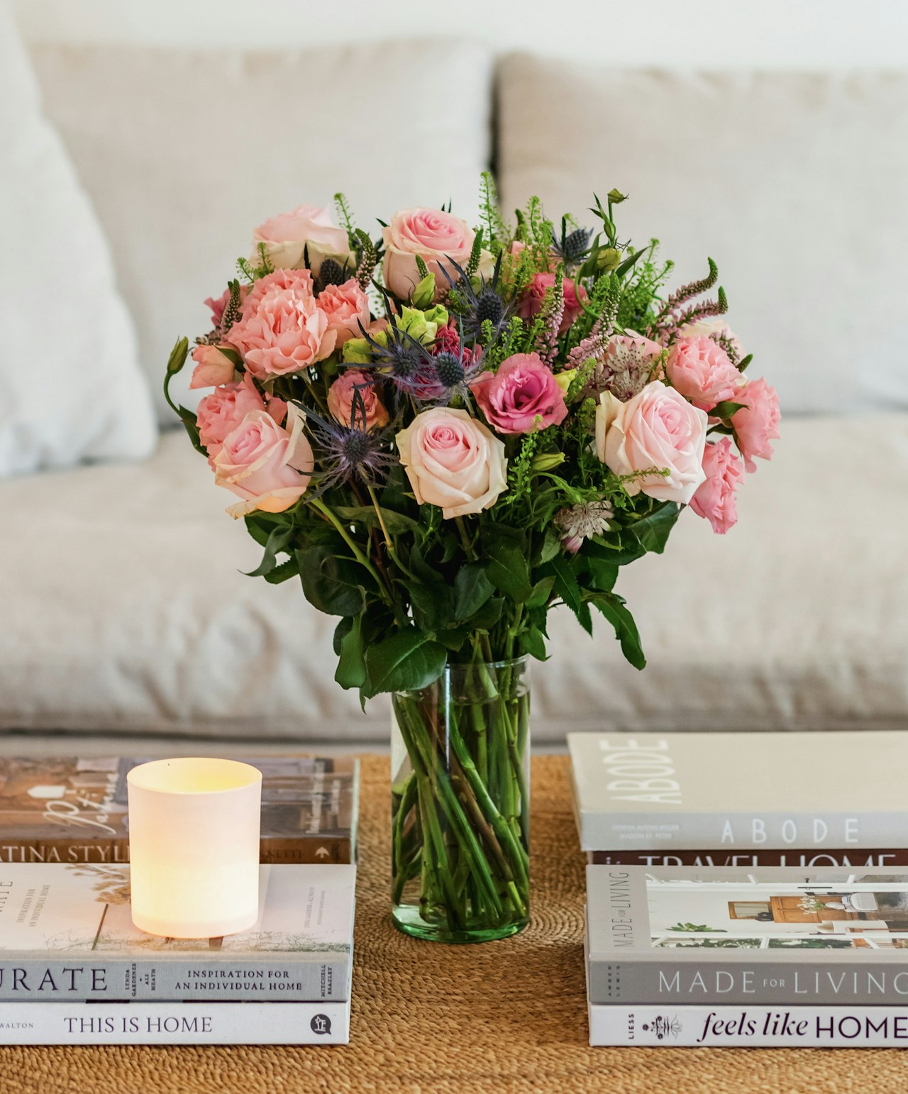 Lush bouquet of pink and cream roses with greenery, displayed on a coffee table.