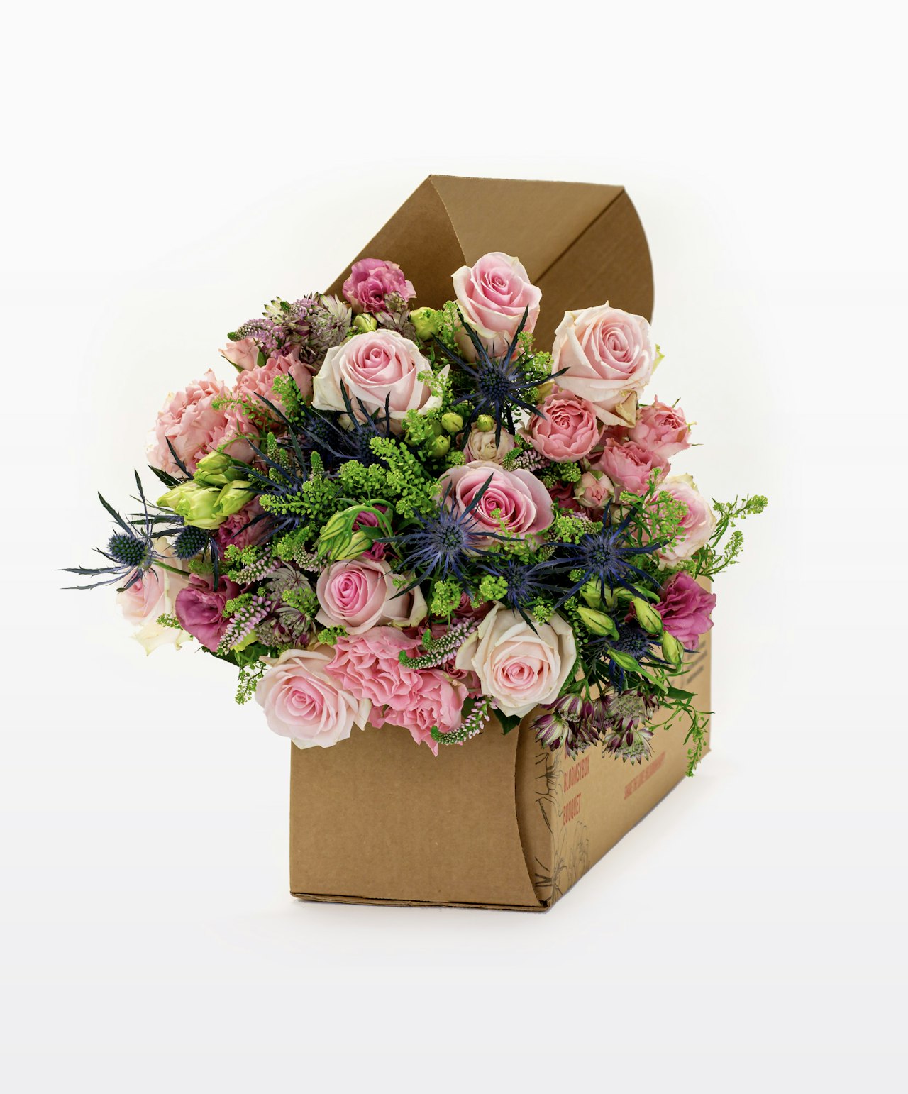 A charming floral arrangement in a stylish box featuring pink roses, green accents, and wildflowers.