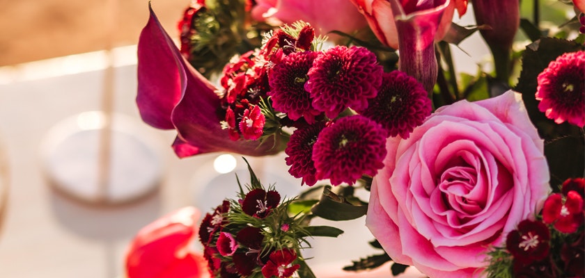 Vibrant floral arrangement featuring pink roses and deep red blooms, elegantly displayed.