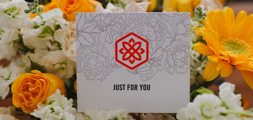 White and yellow flowers surround a greeting card that says "Just For You," perfect for gifting.