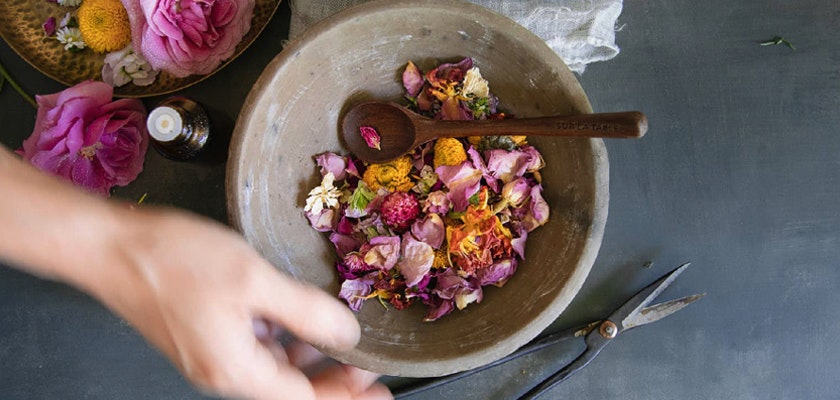 A rustic bowl filled with vibrant dried flowers and herbs, perfect for natural crafts and potpourri.