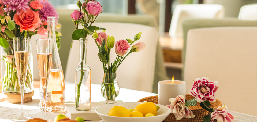 Colorful floral arrangements and refreshing drinks set on a bright, inviting table for a gathering.