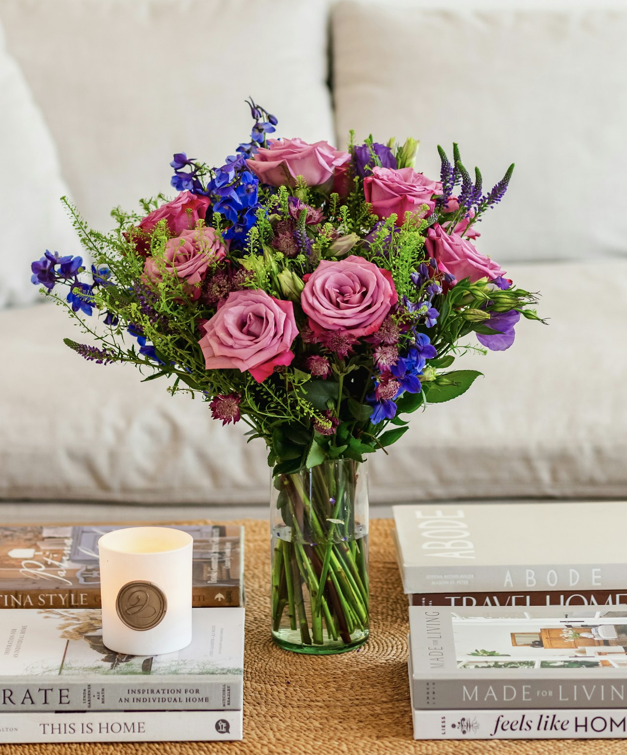 Vibrant floral arrangement featuring pink roses and blue delphiniums in a stylish vase.