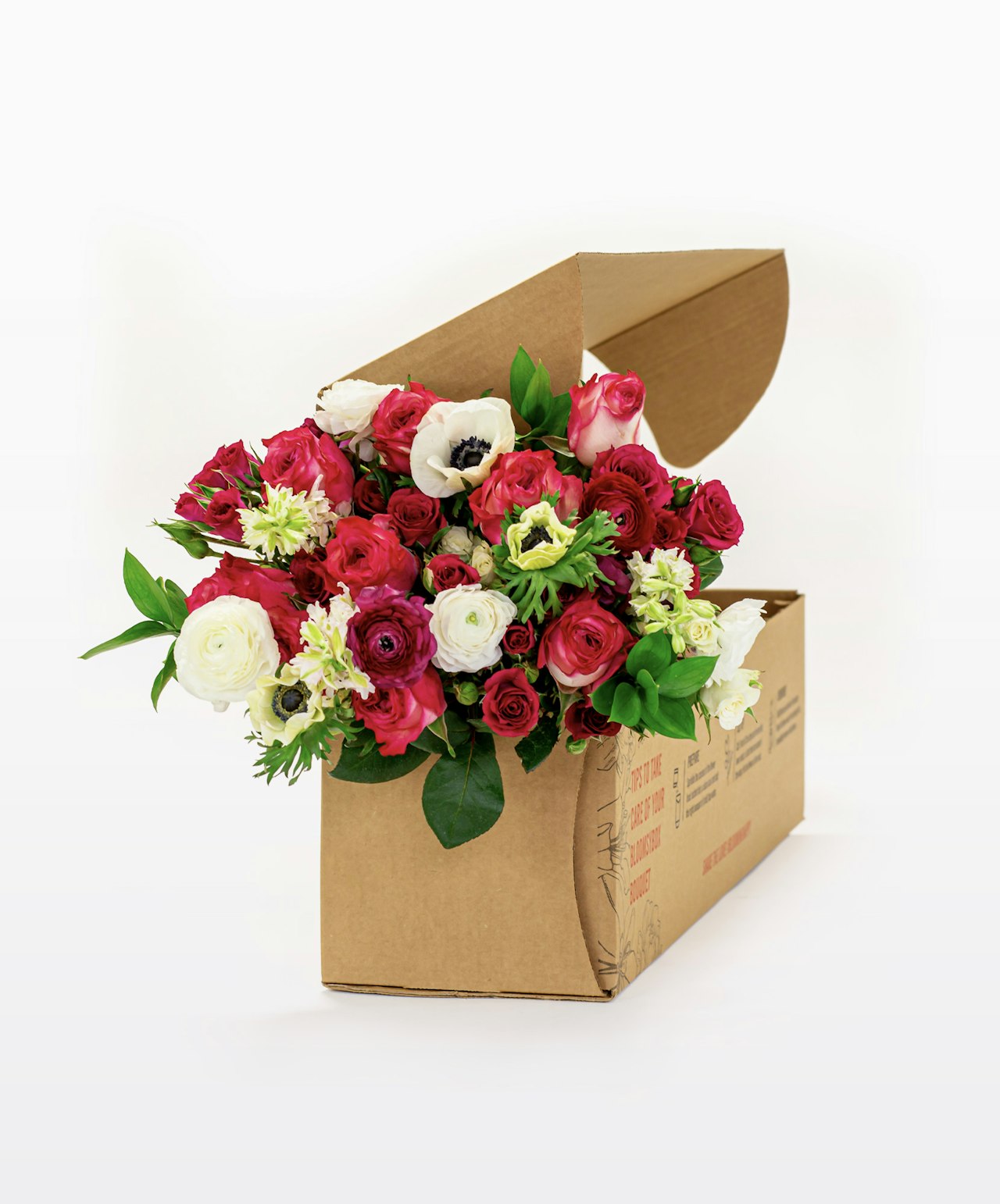 Vibrant floral arrangement featuring red roses, white flowers, and greenery in a stylish box.