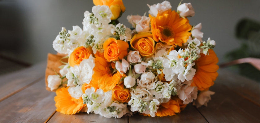 Bright and cheerful floral arrangement featuring yellow roses, gerbera daisies, and white blooms.