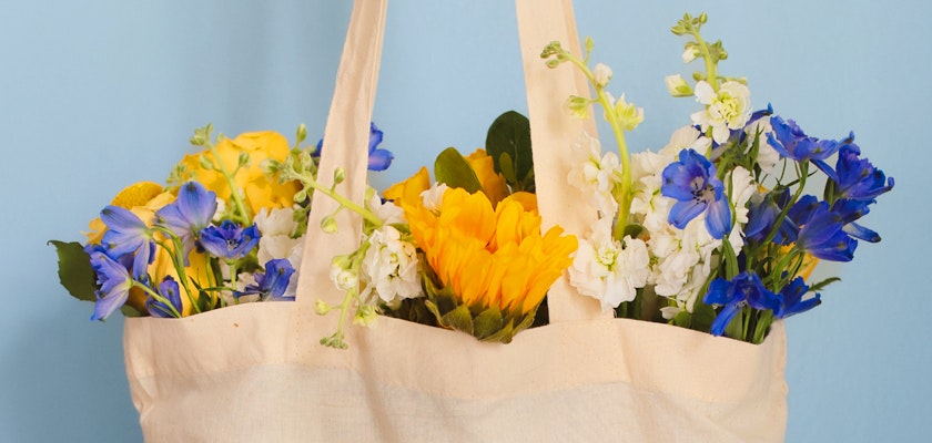 Brightly colored flowers in a tote bag, showcasing a vibrant spring arrangement.