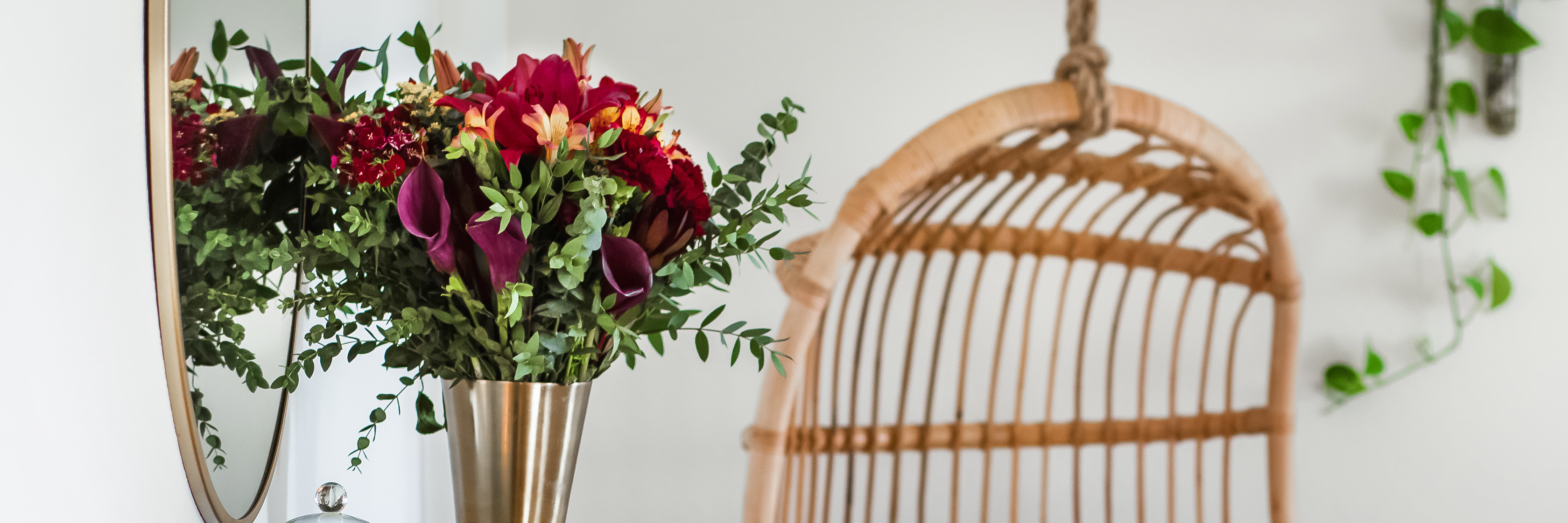 Elegant floral arrangement with deep hues in a modern vase, complementing a cozy interior.