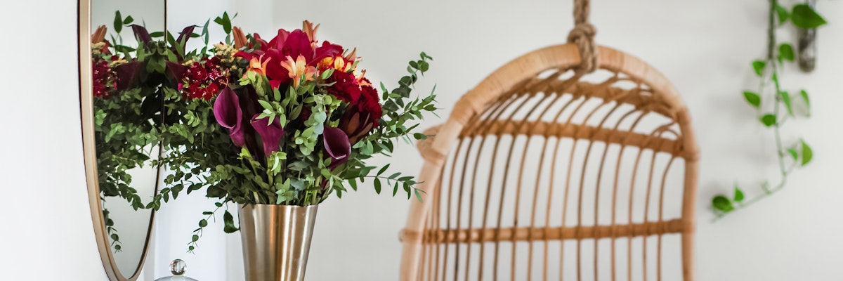 Elegant floral arrangement with deep hues in a modern vase, complementing a cozy interior.