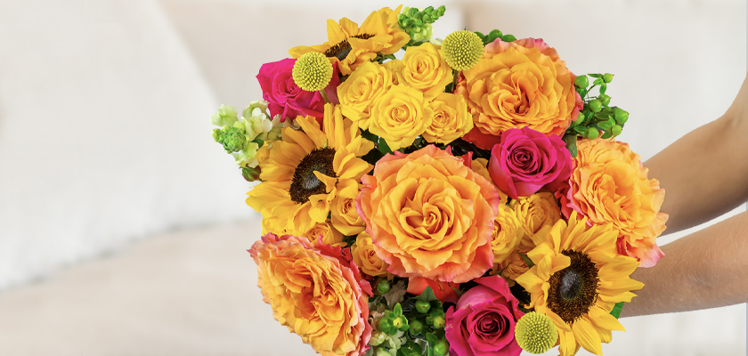 Vibrant bouquet featuring yellow roses, sunflowers, and pink blooms, perfect for celebrations.