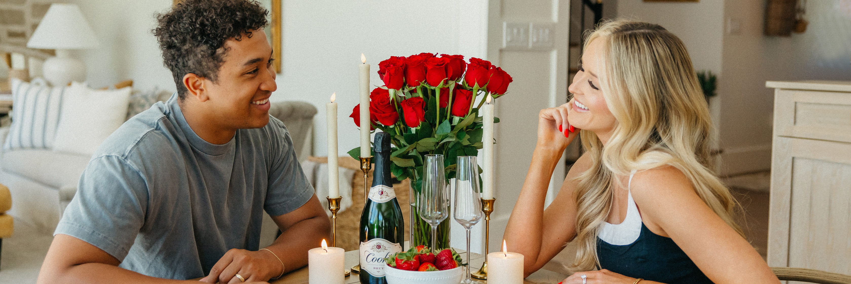 Candlelit dinner for two featuring a romantic rose bouquet and elegant table setting.