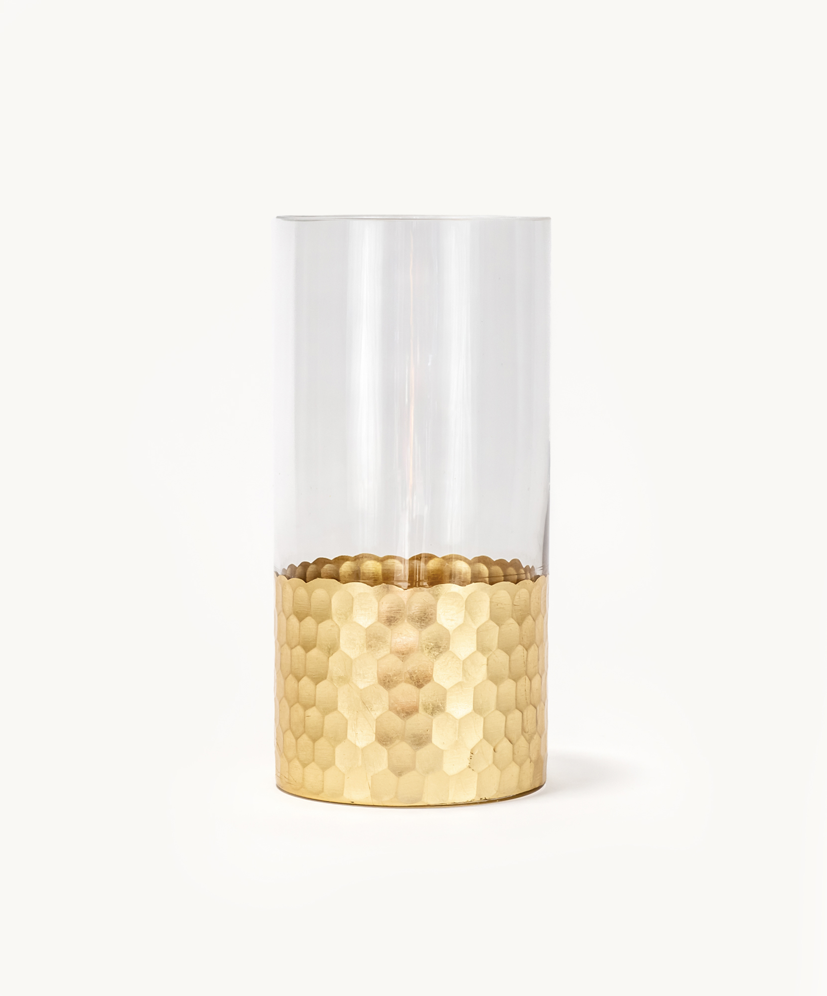 Elegant glass candle holder with a textured gold base, perfect for home decor.