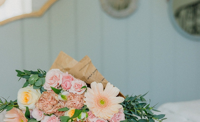 Delicate bouquet featuring pink roses, gerbera daisies, and greenery, perfect for celebrations.