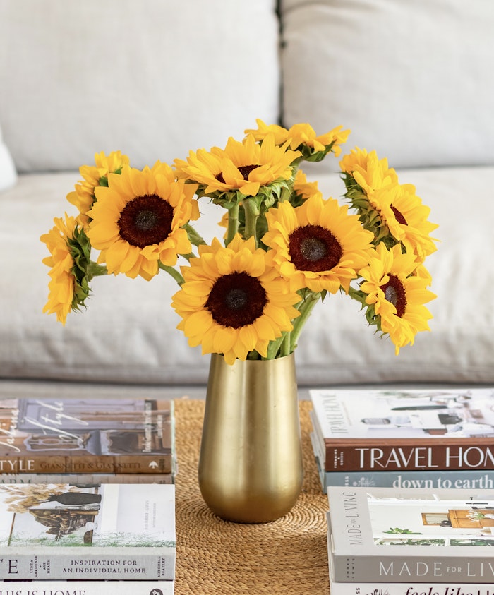 Bright and cheerful sunflower bouquet in a gold vase, adding warmth to any room decor.