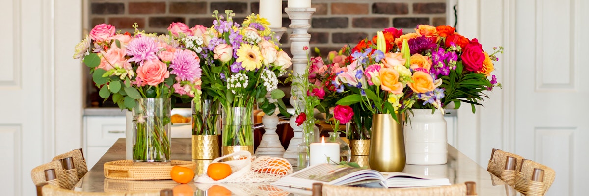 Vibrant floral centerpieces featuring assorted blooms, elegantly arranged on a dining table.