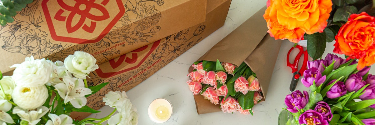 Colorful flower arrangements featuring roses, tulips, and carnations in elegant packaging.