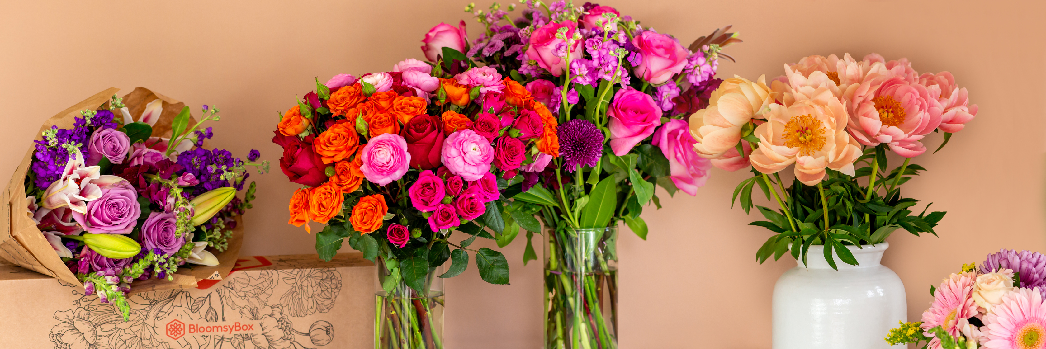 Vibrant floral display featuring mixed bouquets of roses, peonies, and lilies in elegant vases.