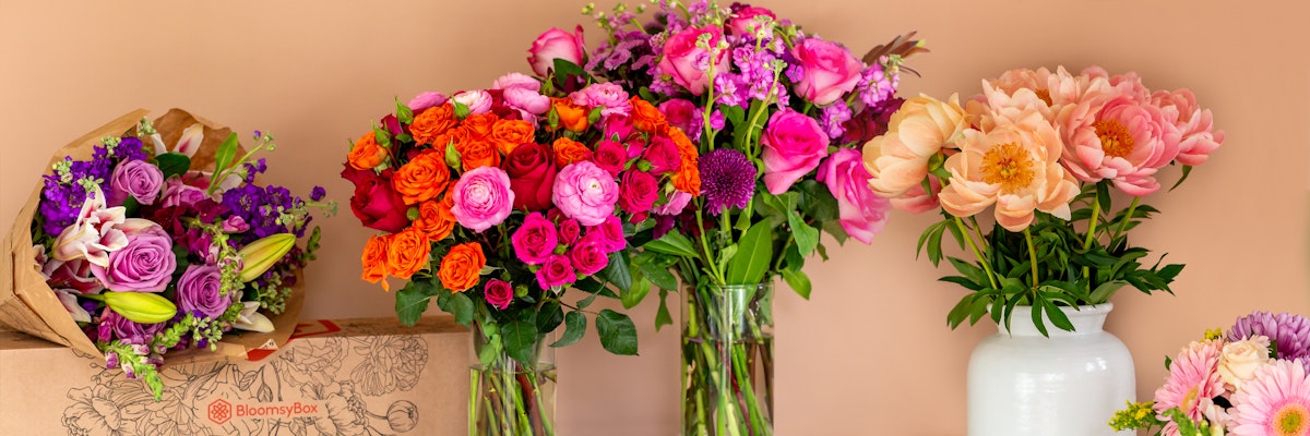 Vibrant floral display featuring mixed bouquets of roses, peonies, and lilies in elegant vases.