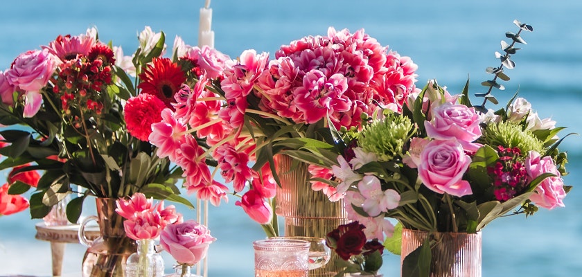 Vibrant floral arrangements featuring roses, tulips, and daisies by the seaside.