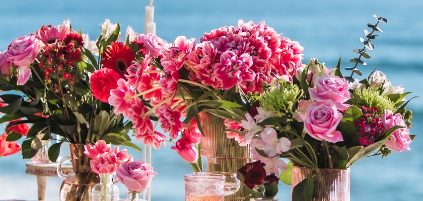 Vibrant floral arrangements featuring roses, tulips, and daisies by the seaside.