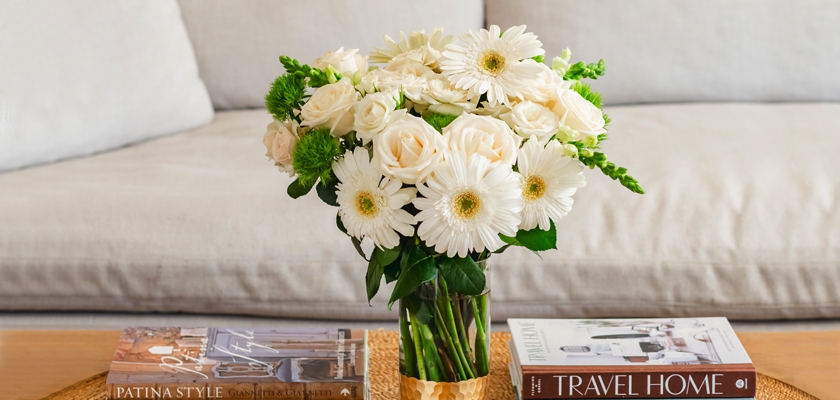 Elegant bouquet of white roses and gerbera daisies in a stylish glass vase, perfect for home decor.