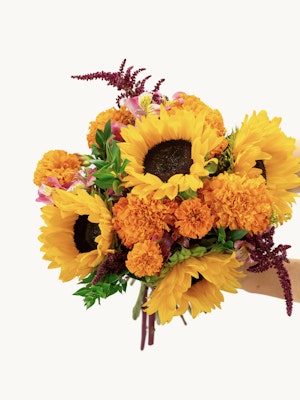 Vibrant sunflower bouquet with marigolds and colorful accents, perfect for cheerful occasions.