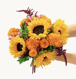Vibrant sunflower bouquet with marigolds and colorful accents, perfect for cheerful occasions.