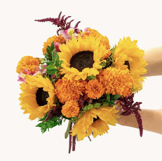 Vibrant sunflower bouquet with marigolds and colorful accents, perfect for cheerful occasions.