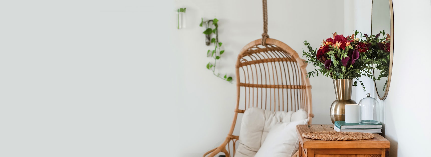 Cozy living space featuring a wicker chair, a stunning floral arrangement, and greenery accents.