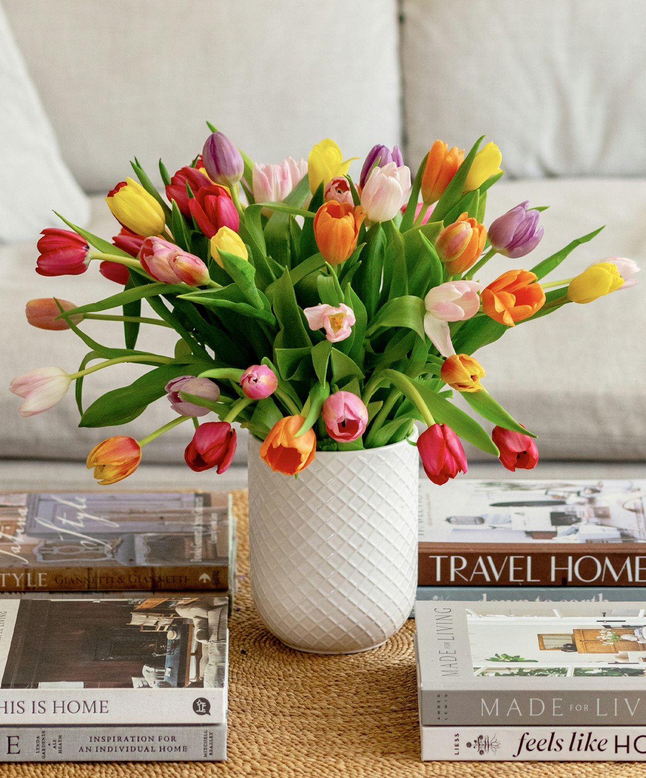 Vibrant bouquet of multi-colored tulips in a textured vase, perfect for spring decor.