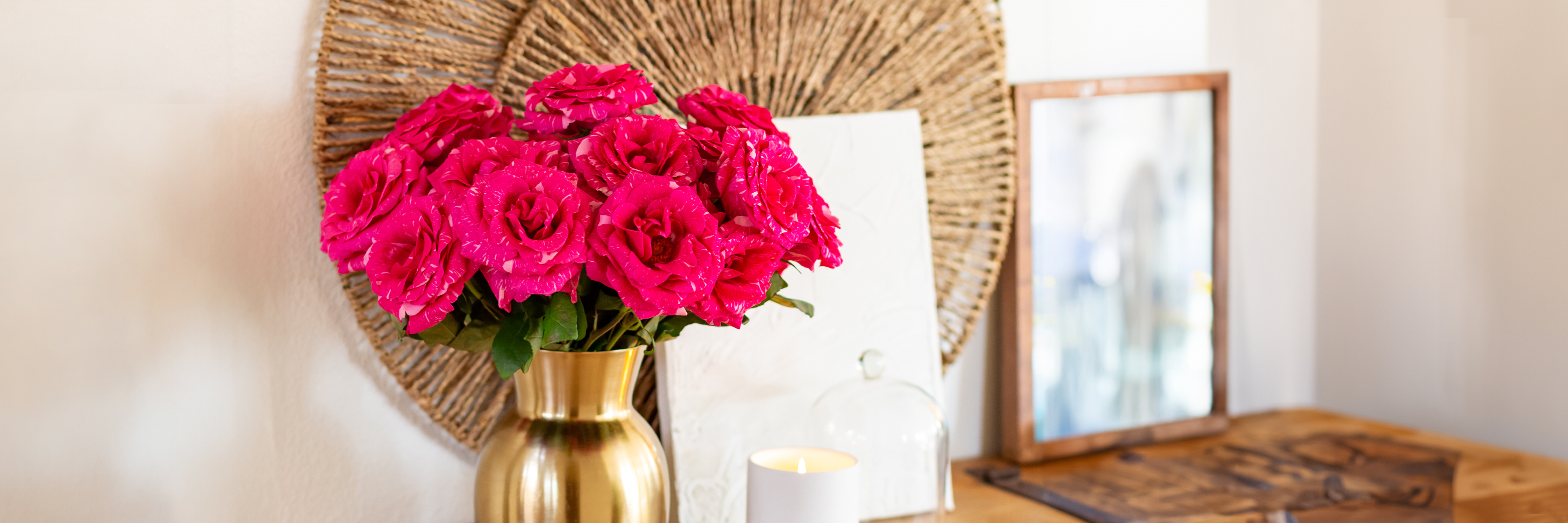 Vibrant pink roses in a stylish gold vase, enhancing a chic home decor setting.