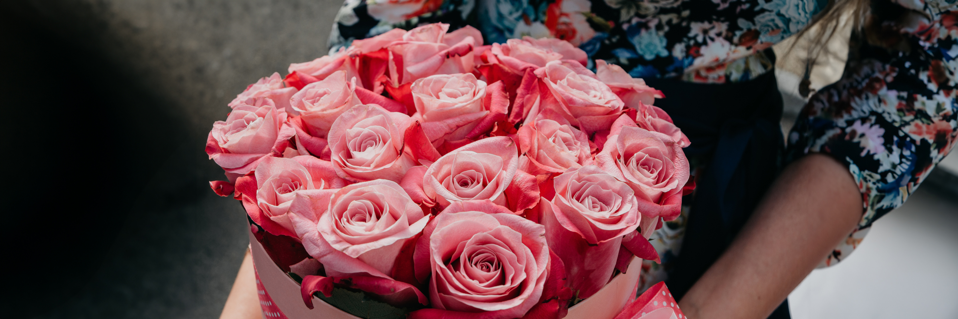 Beautiful pink roses artfully arranged in a round floral box, perfect for gifting.