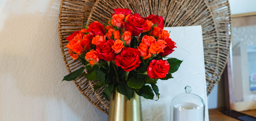 Vibrant bouquet of red and orange roses in a stylish vase, enhancing home decor with natural beauty.