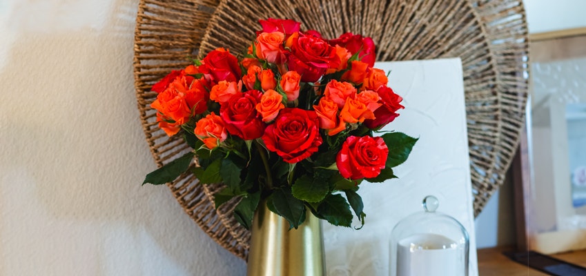 Vibrant bouquet of red and orange roses in a stylish vase, enhancing home decor with natural beauty.