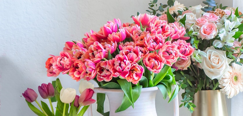 Vibrant pink tulips and soft roses arranged in a charming floral display.