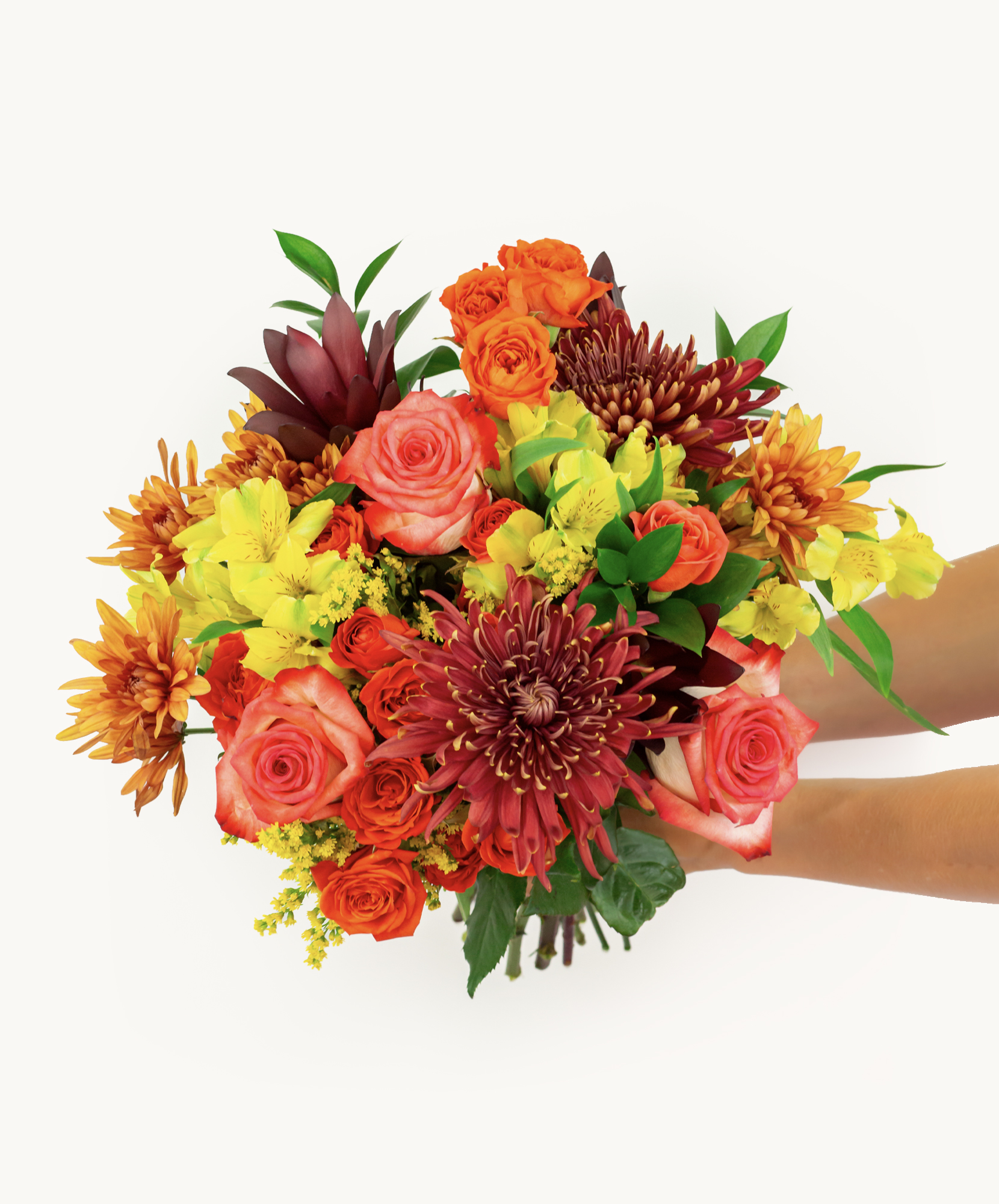 Vibrant floral bouquet featuring roses, lilies, and chrysanthemums in warm autumn tones.