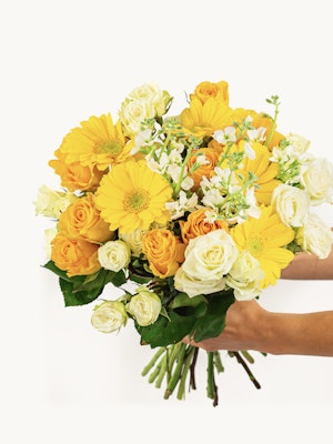 Vibrant bouquet featuring yellow gerbera daisies and romantic roses, perfect for celebrations.