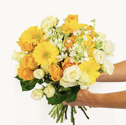 Vibrant bouquet featuring yellow gerbera daisies and romantic roses, perfect for celebrations.