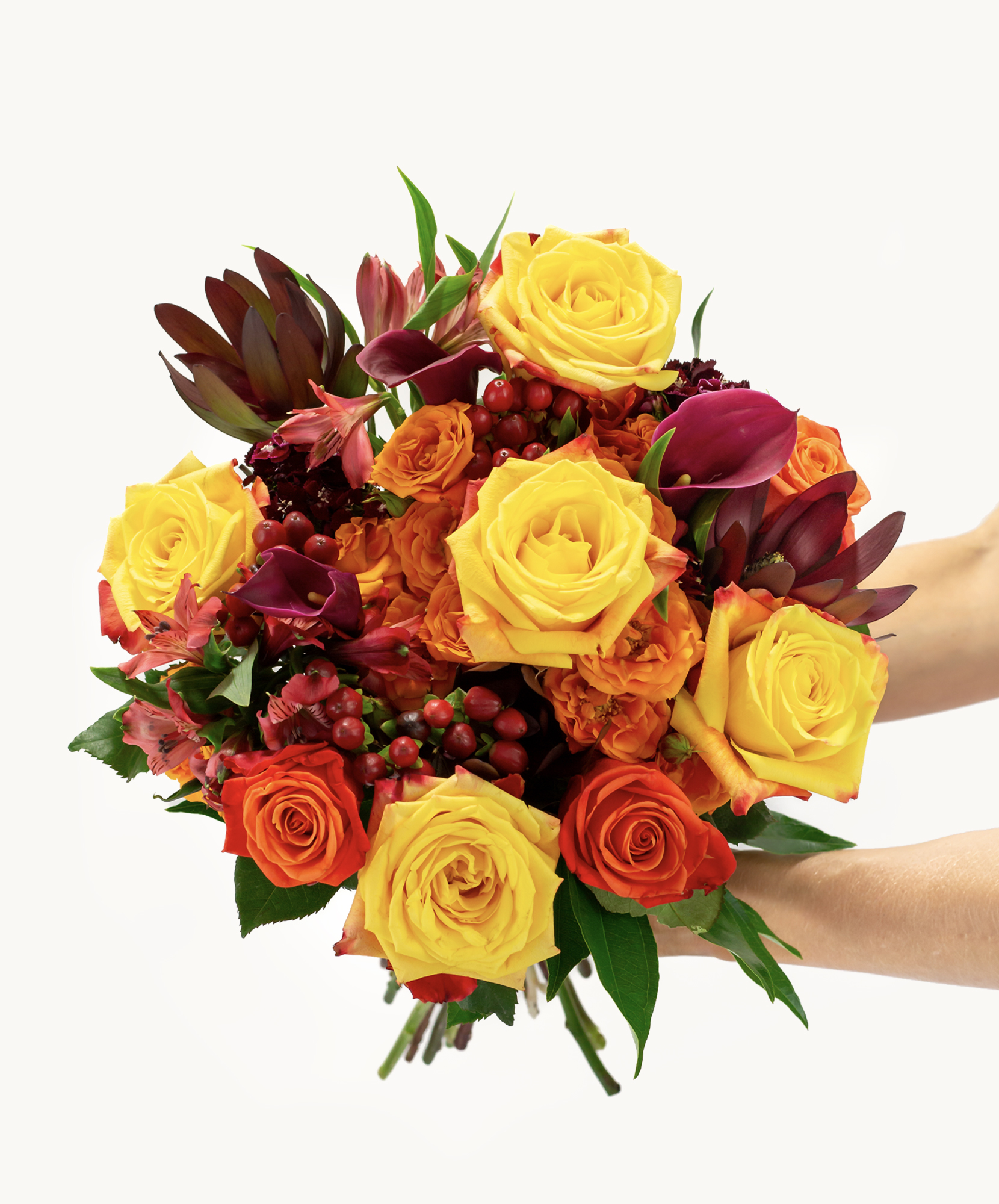 Vibrant bouquet of yellow and orange roses mixed with lush greenery, perfect for celebrations.