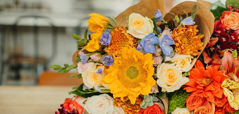 Vibrant floral bouquet featuring sunflowers, roses, and colorful blooms for any celebration.