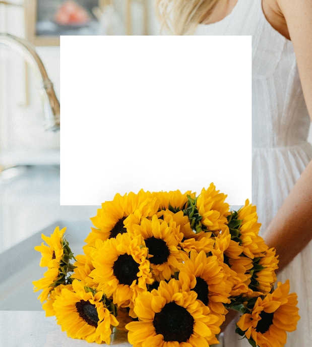 Vibrant bouquet of sunflowers held by a woman in a light dress, brightening any space.