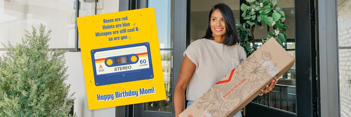 A woman smiles while holding a floral gift box, celebrating a special birthday occasion.