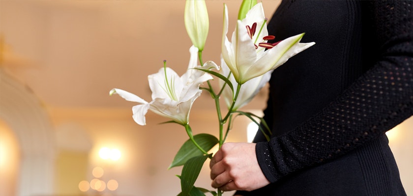 Elegant white lilies held by a woman in a black outfit, perfect for conveying beauty and grace.
