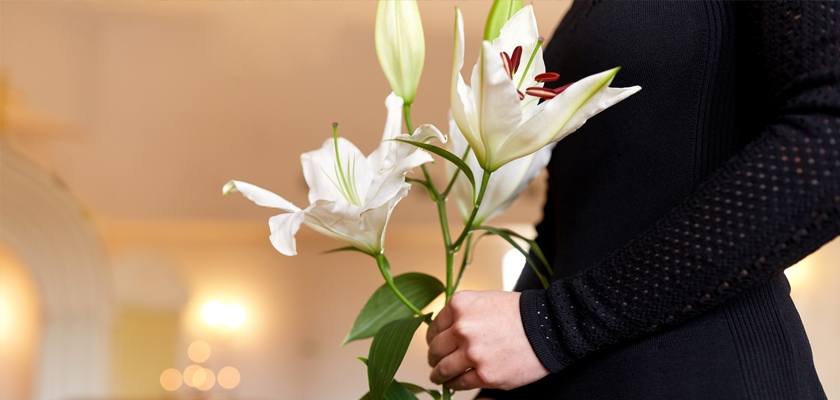 Elegant white lilies held by a woman in a black outfit, perfect for conveying beauty and grace.