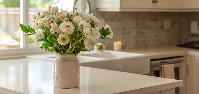 Elegant white floral arrangement in a vase, brightening a modern kitchen space.