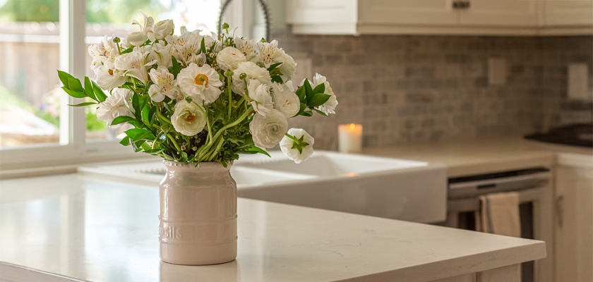 Elegant white floral arrangement in a vase, brightening a modern kitchen space.