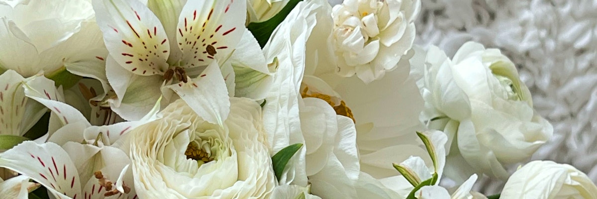 Elegant white floral arrangement featuring roses and delicate lilies, perfect for any occasion.